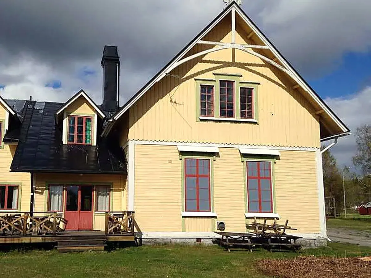 Hägragårdens gula träbyggnad med altan — bygdegården i Hägra